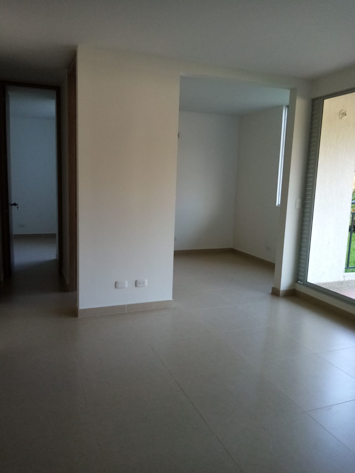 Una habitación vacía con paredes blancas y una ventana grande