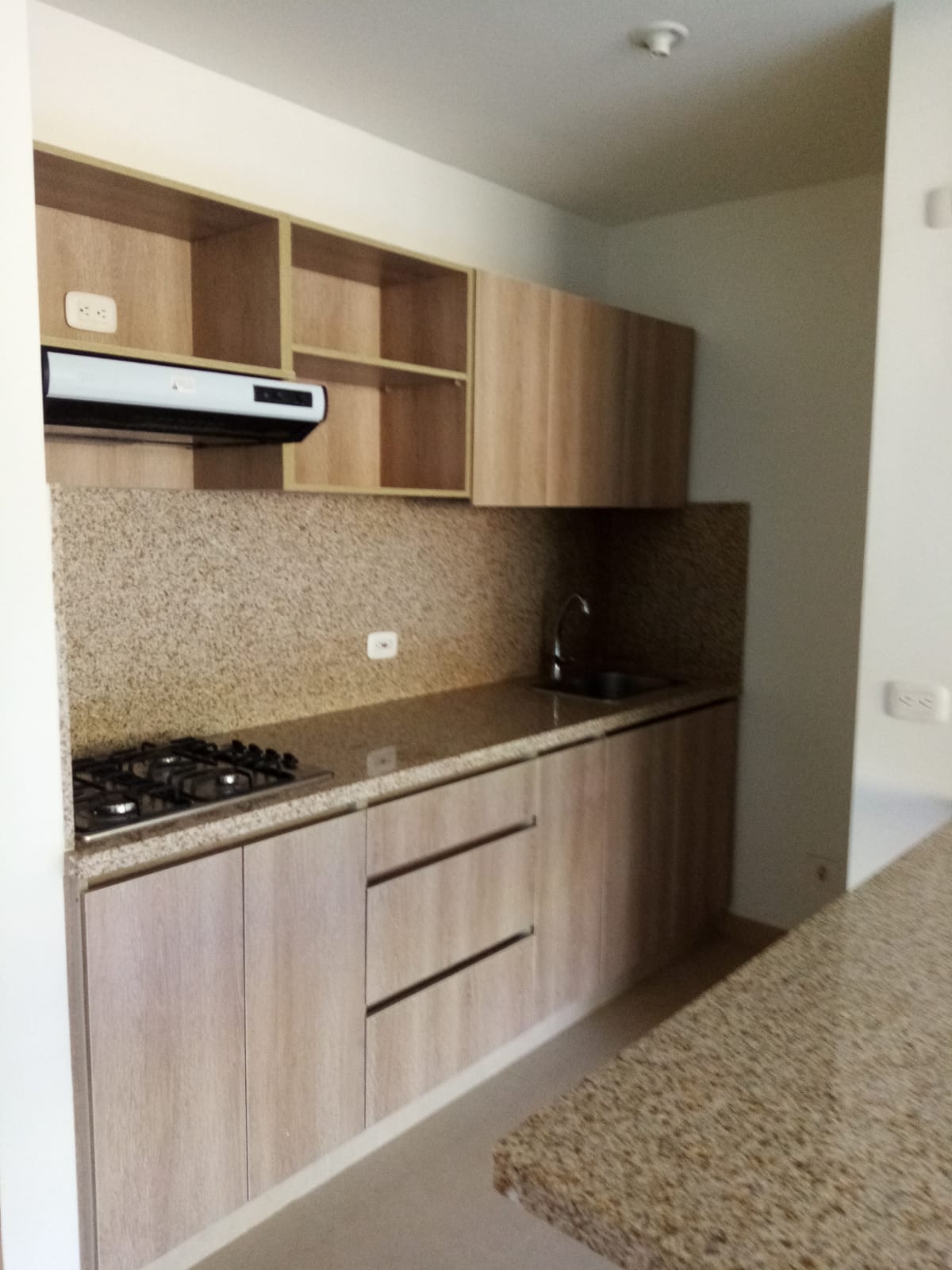 Una cocina con gabinetes de madera y encimeras de granito