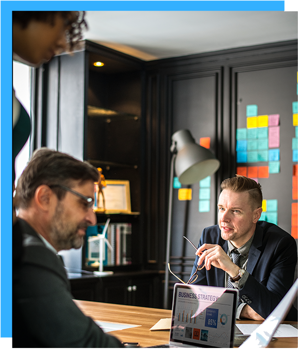 Professionals engaged in a business strategy meeting on either side of a desk