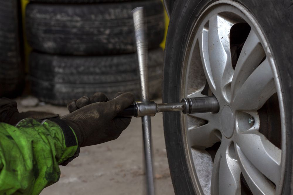 A Person is Changing a Tyre on a Car — Turbo's Tyres In Humpty Doo, NT