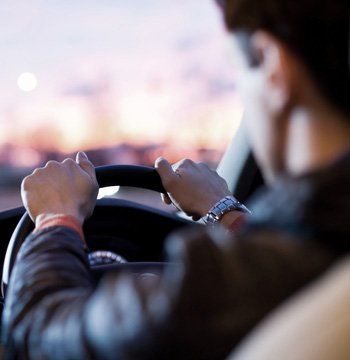 A man with his hands on a steering wheel
