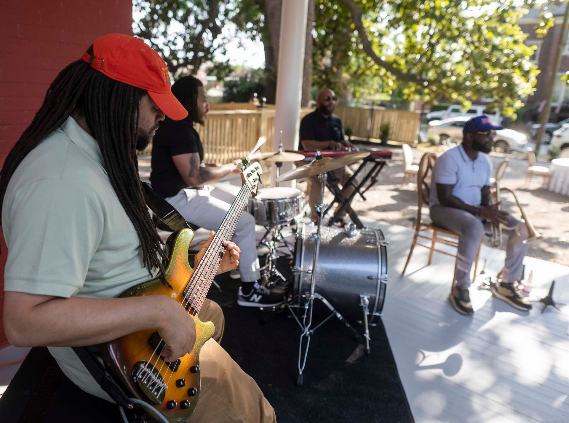 A man is playing a guitar in front of a drum set