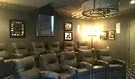 A home theater with a lot of chairs and a chandelier.