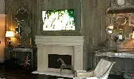 A living room with a fireplace and a flat screen tv on the wall.