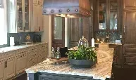 A kitchen with granite counter tops , stainless steel appliances , and a large island.