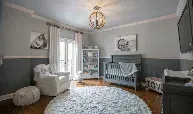 A nursery with a crib , chair , and rug.
