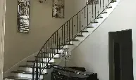 A black and white photo of a staircase in a house.