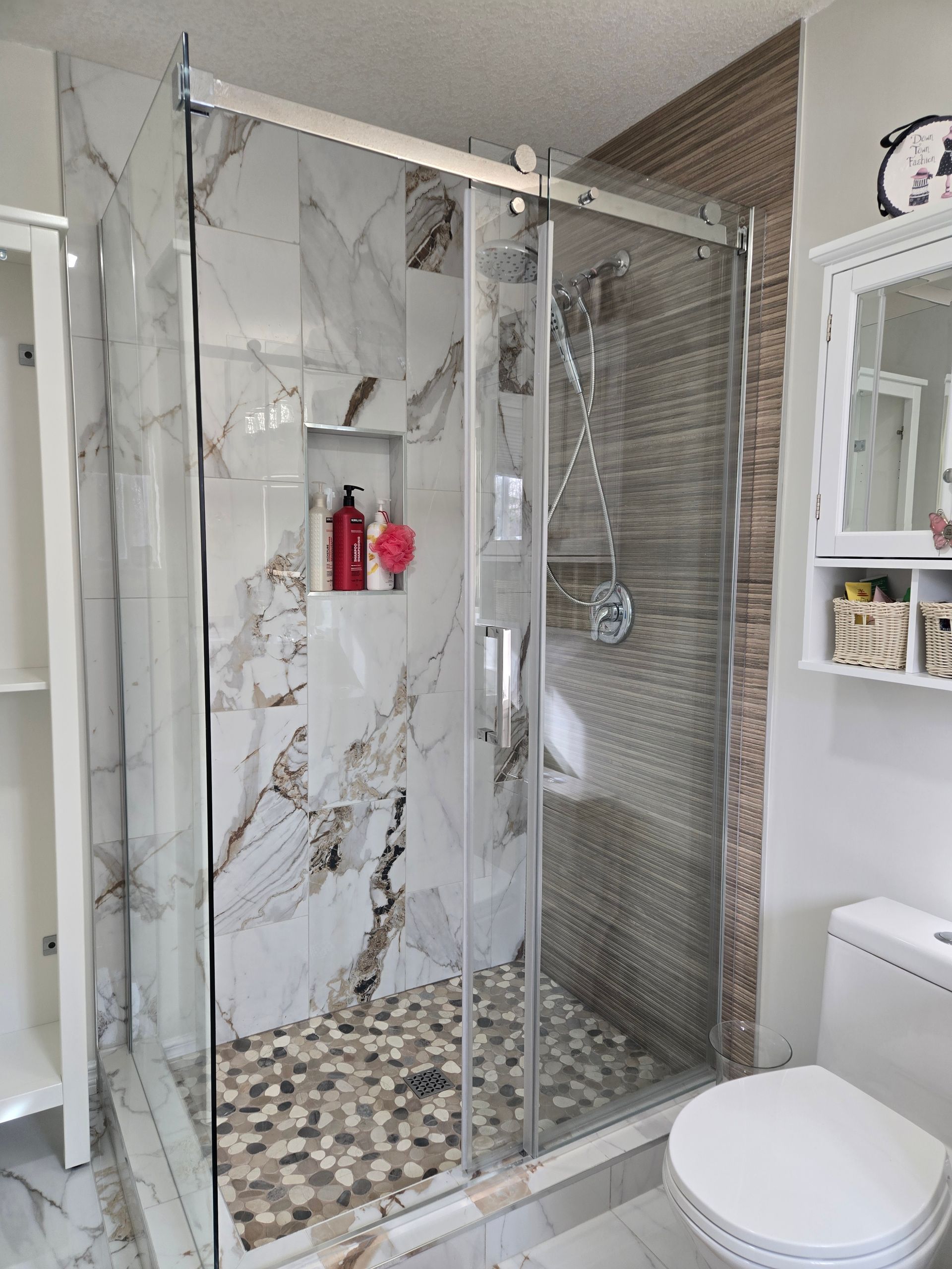 Modern glass shower with marble-look and wood-look tiles in Sherwood Park by XMP Construction.