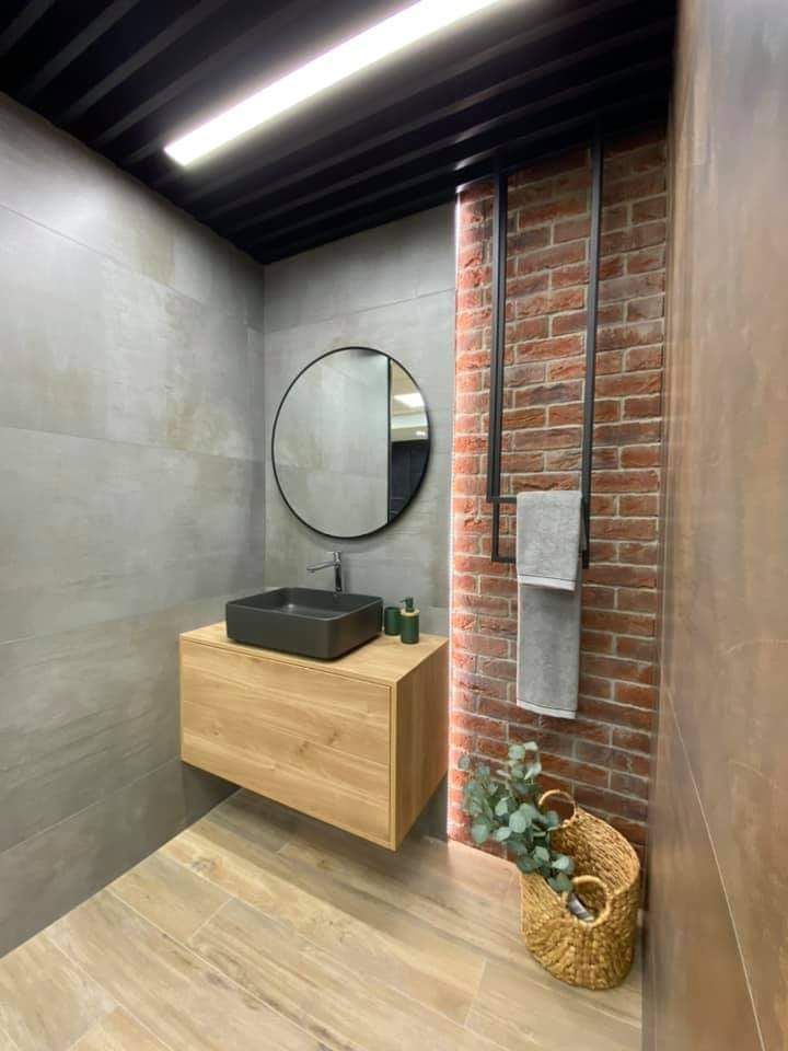 Bathroom vanity in a space that combines brick and concrete-style large format tile for a unique industrial look