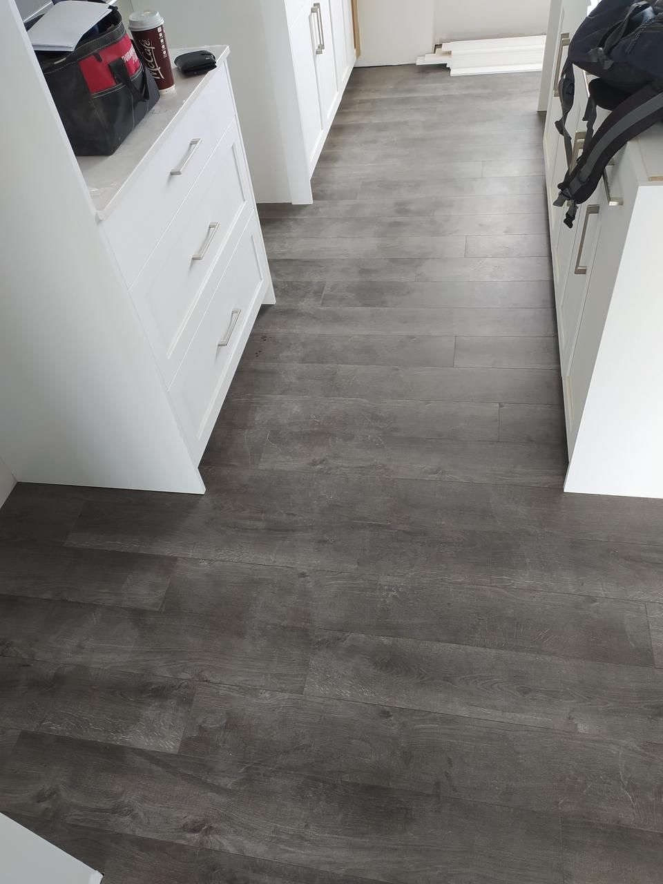 Installation of luxury vinyl plank flooring in a Sherwood Park kitchen by XMP Construction.