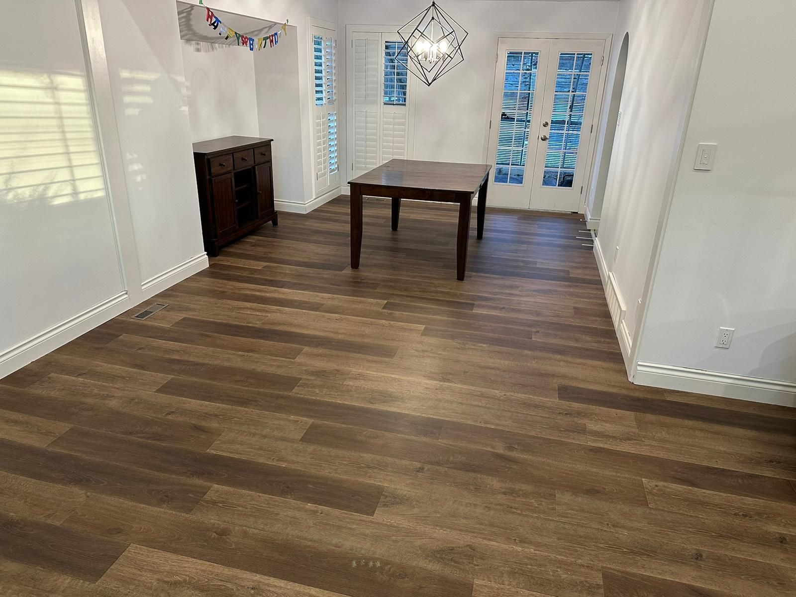 Dark wood-look luxury vinyl plank flooring in a Sherwood Park dining room by XMP Construction.