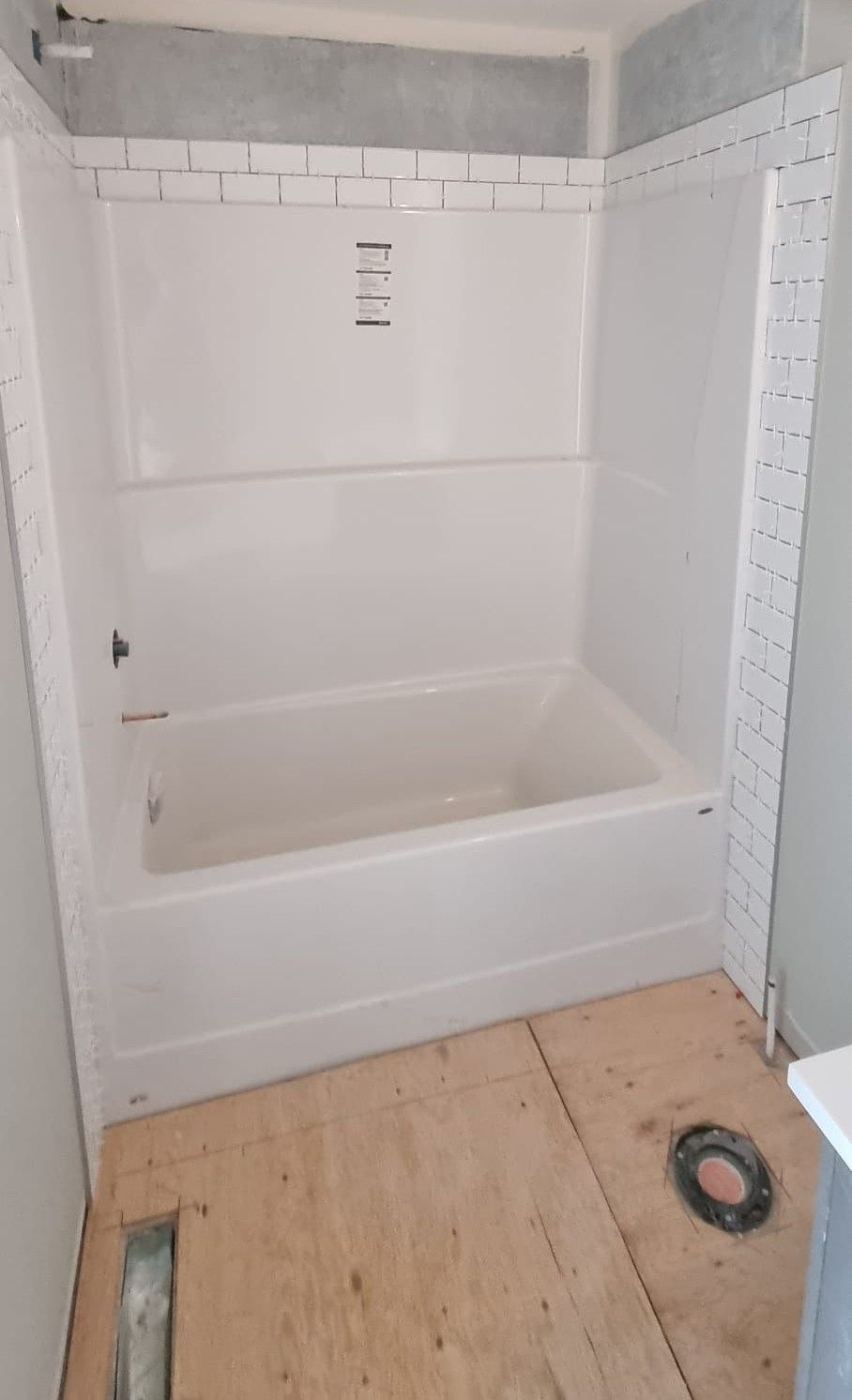 Installation of white subway tiles around a bathtub in a Sherwood Park bathroom by XMP Construction.