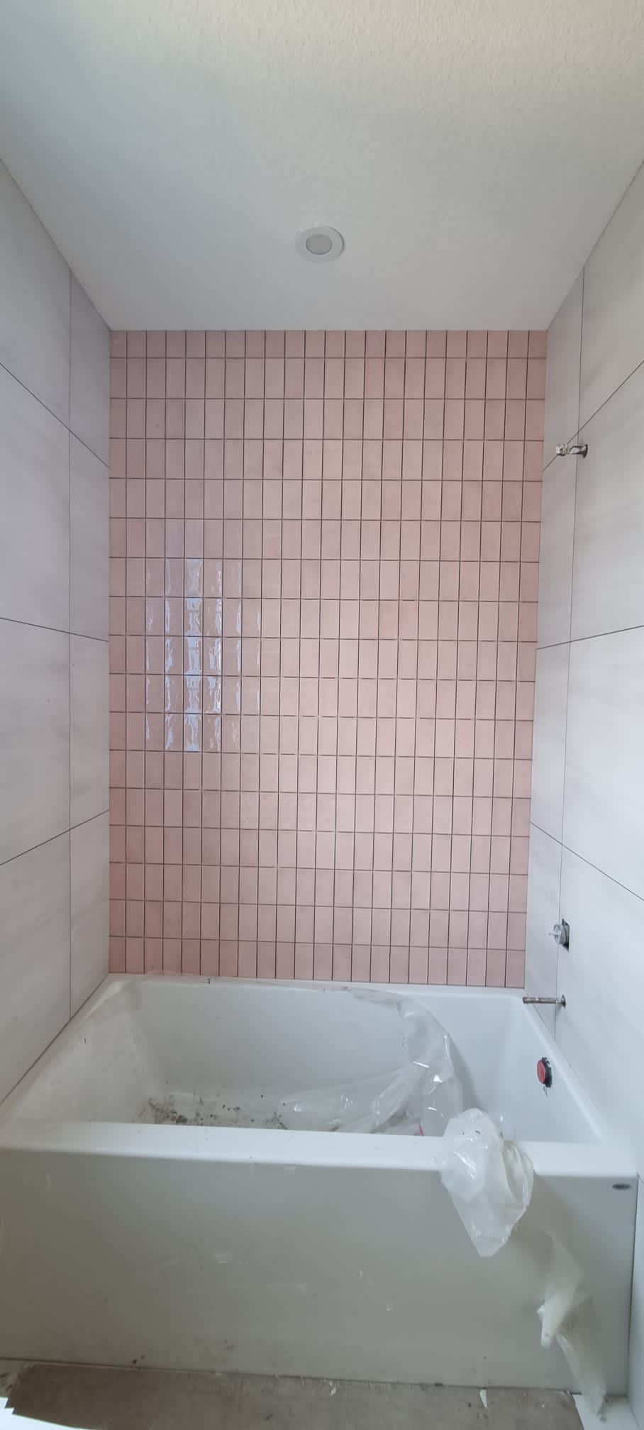 Installation of pink square tiles in a Sherwood Park bathtub surround by XMP Construction.