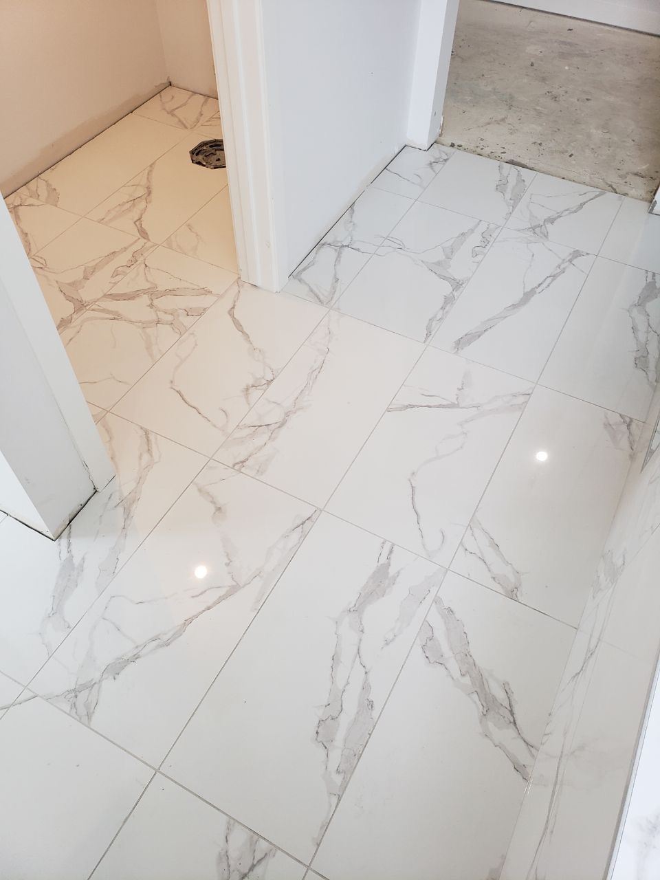Installation of marble-look floor tiles in a Sherwood Park home by XMP Construction.