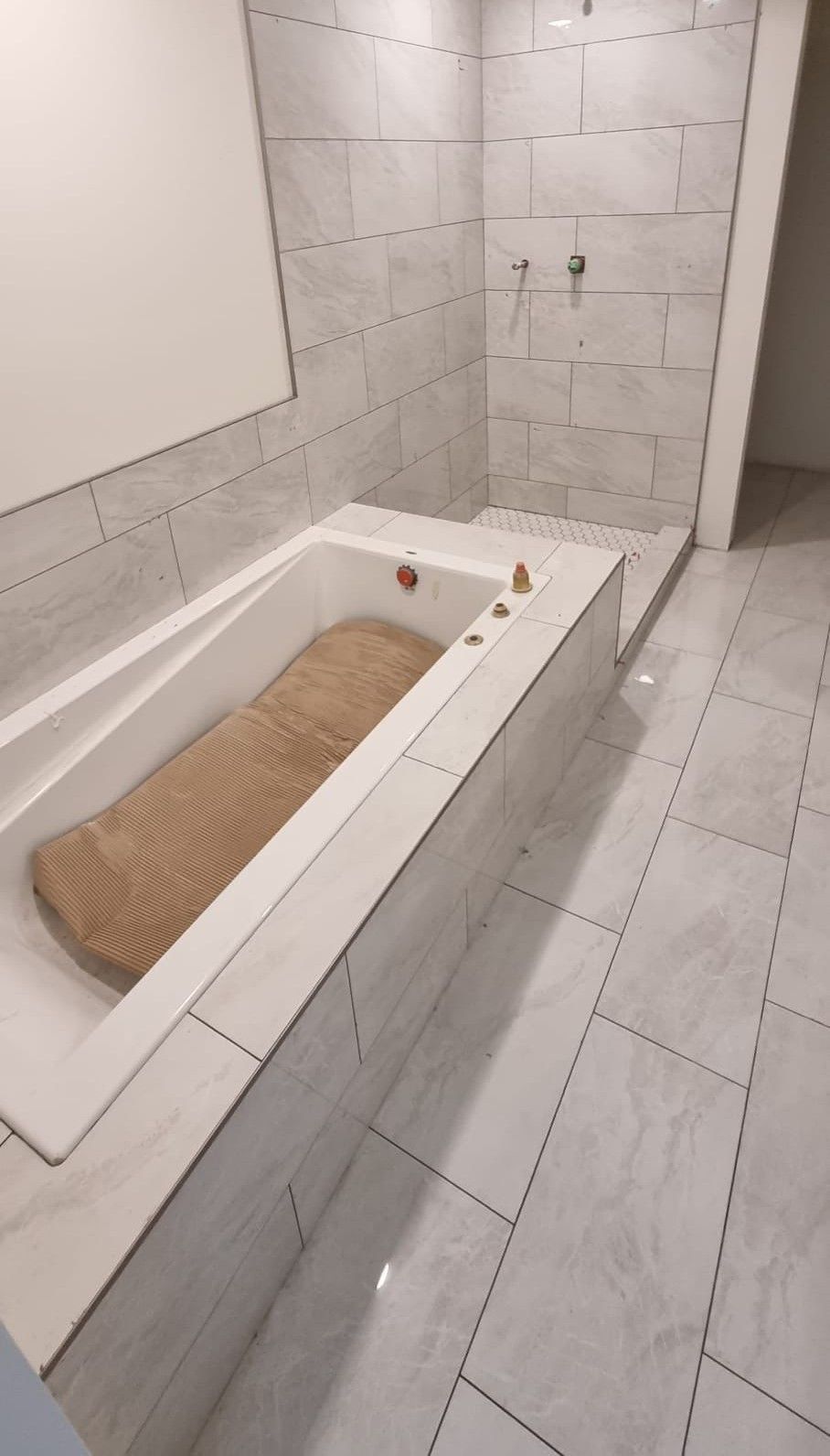 Modern Sherwood Park bathroom with large light grey tiles, a built-in tub, and a shower by XMP Construction.