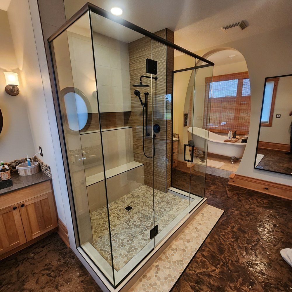 Custom walk-in shower with pebble tile floor and built-in bench installed by XMP Construction in Sherwood Park bathroom.