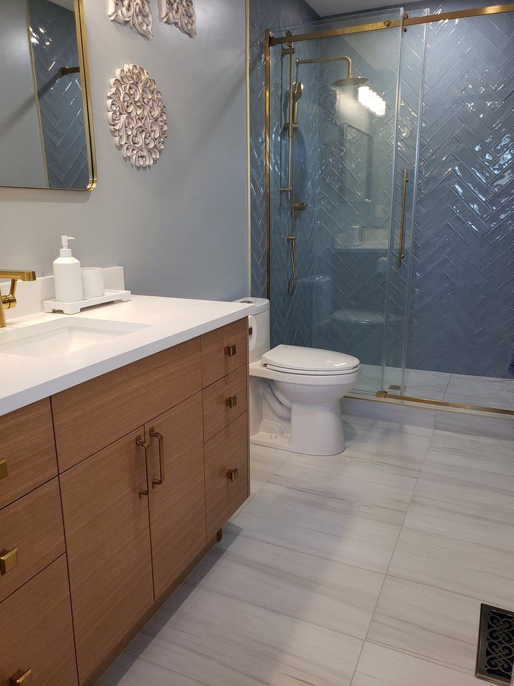 Stylish Sherwood Park bathroom with herringbone shower tiles and wood-look vanity by XMP Construction.
