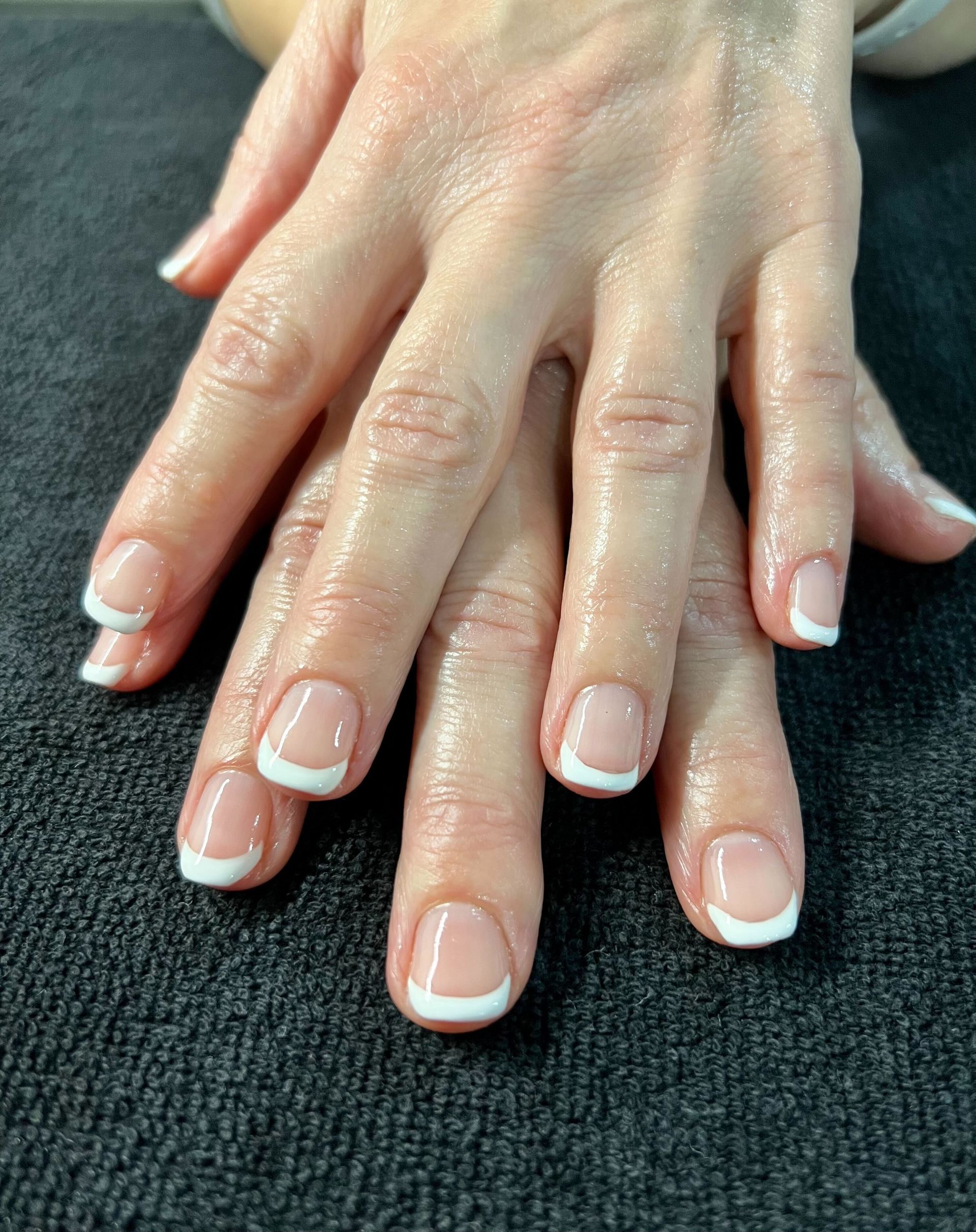 a close up of a woman 's nails with french manicure