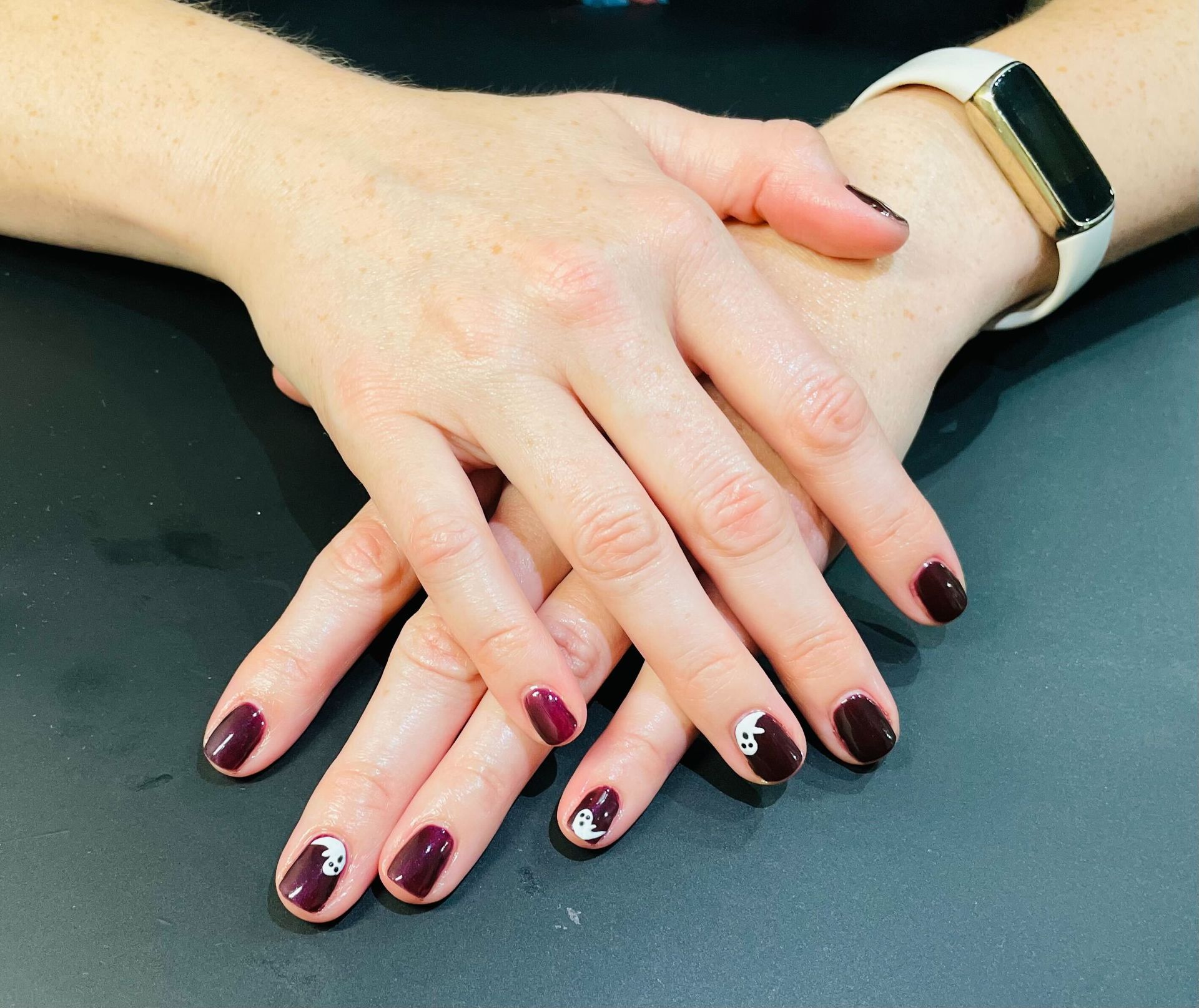 a woman 's hands with a watch on her wrist nails done