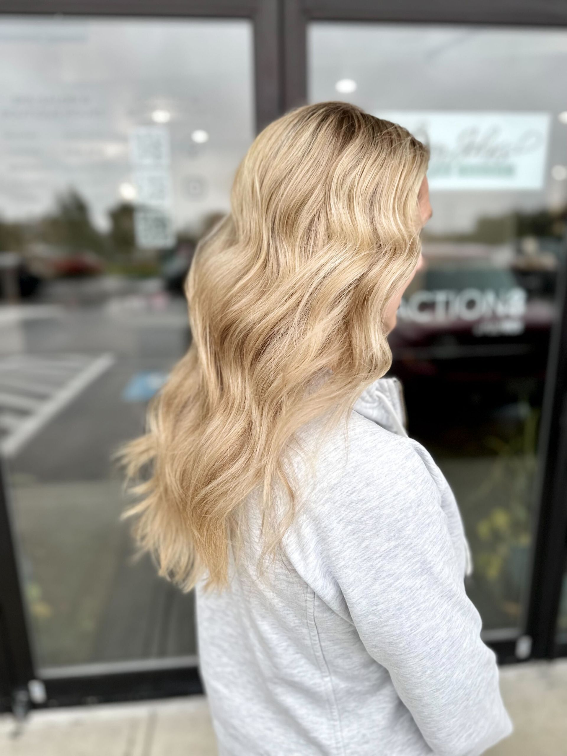 a woman with blonde hair is standing in front of the  Anthony John's building