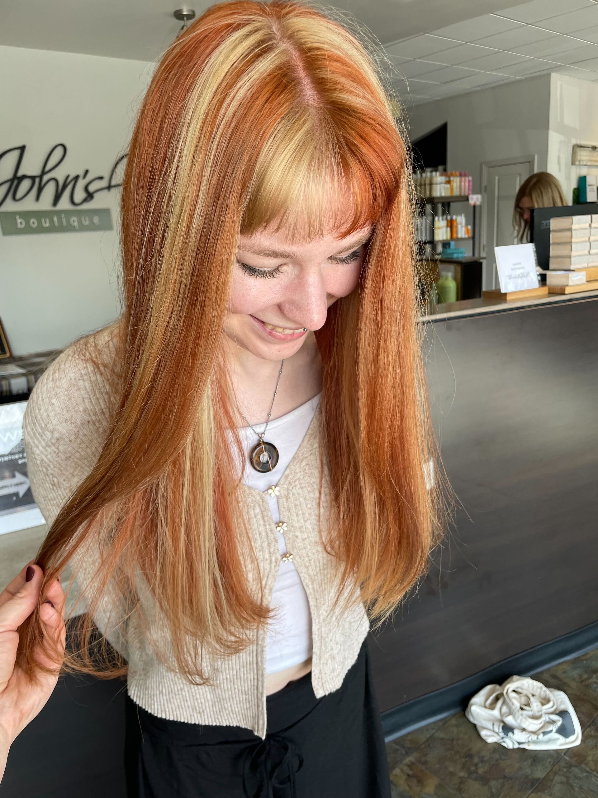 a woman with fun fall hair is standing in front of Anthony johns boutique