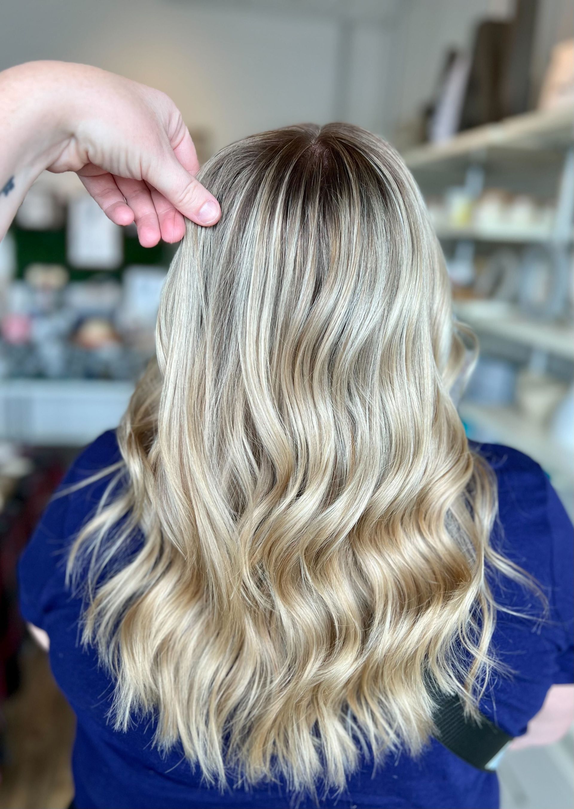 a woman 's blonde hair is being touched by a hand