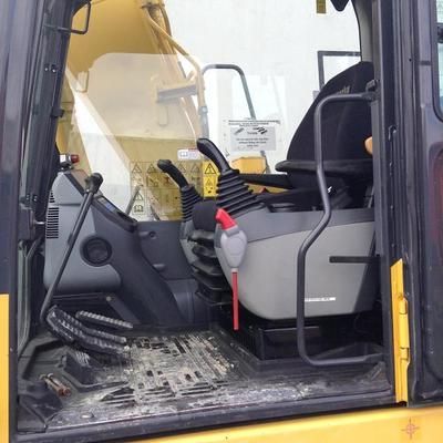 The inside of a yellow and black excavator with the door open.
