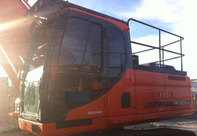 An orange doosan excavator is parked in a parking lot