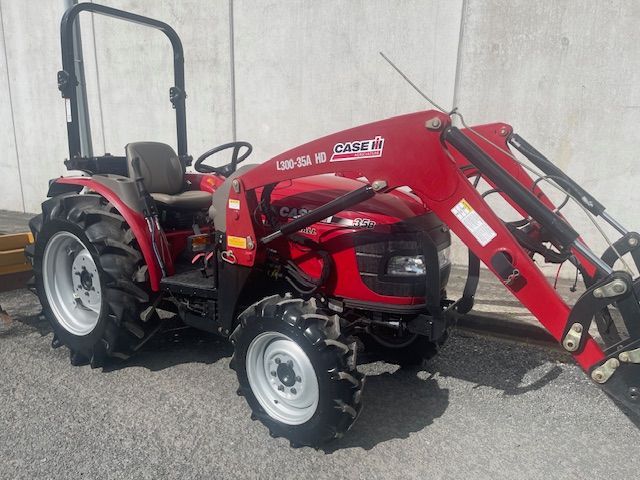 A red tractor with a front loader attached to it