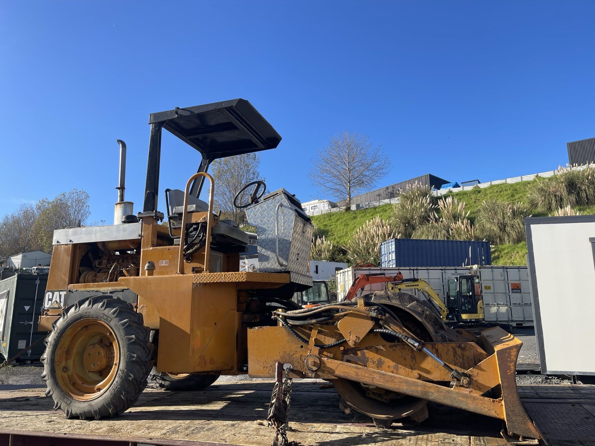 A bulldozer is parked on top of a flatbed truck.