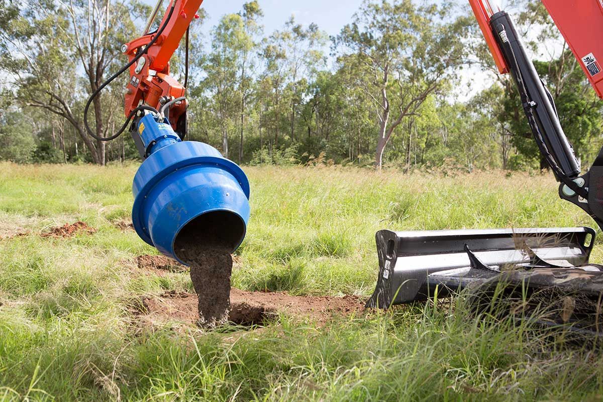 A blue bucket is being used to dig a hole in the ground.