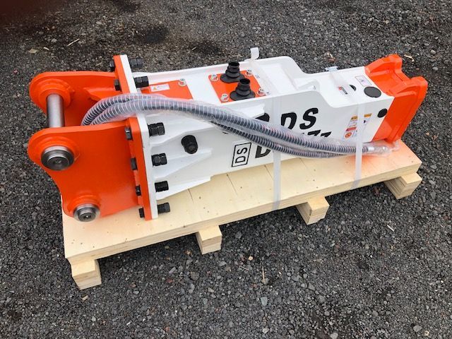 A white and orange machine is sitting on top of a wooden pallet.