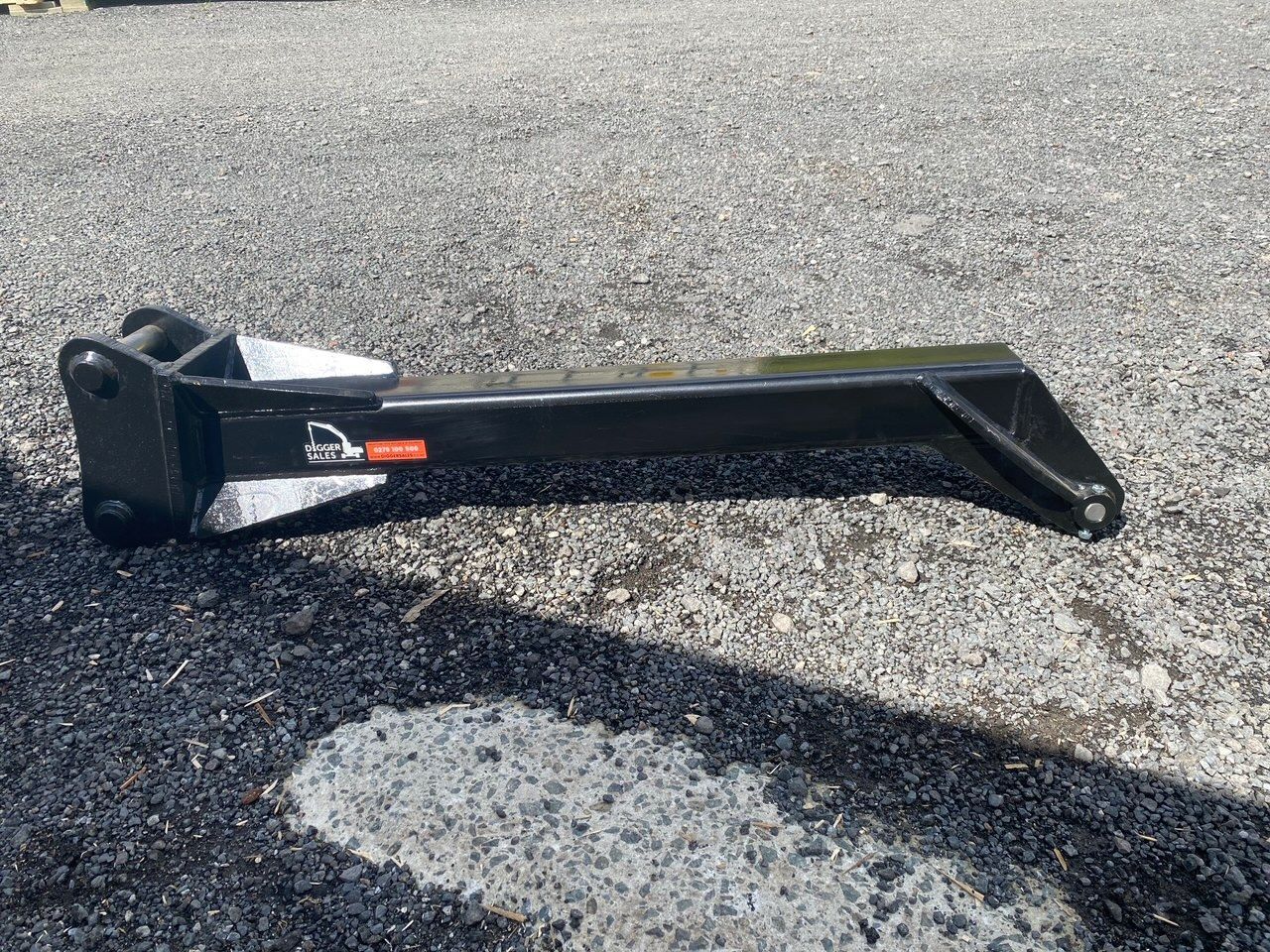 A black object is sitting on top of a gravel road.