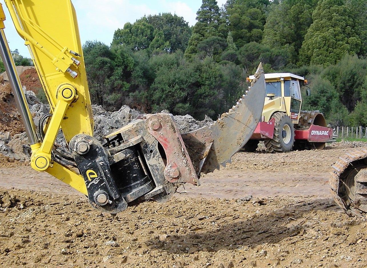 A yellow excavator is digging a hole in the dirt.
