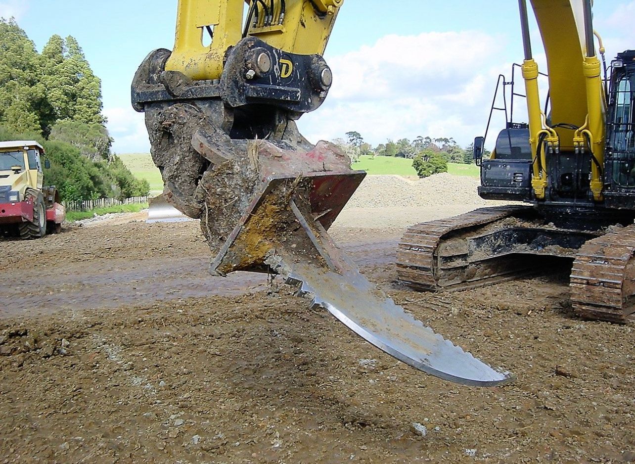 A yellow excavator is digging a hole in the dirt.