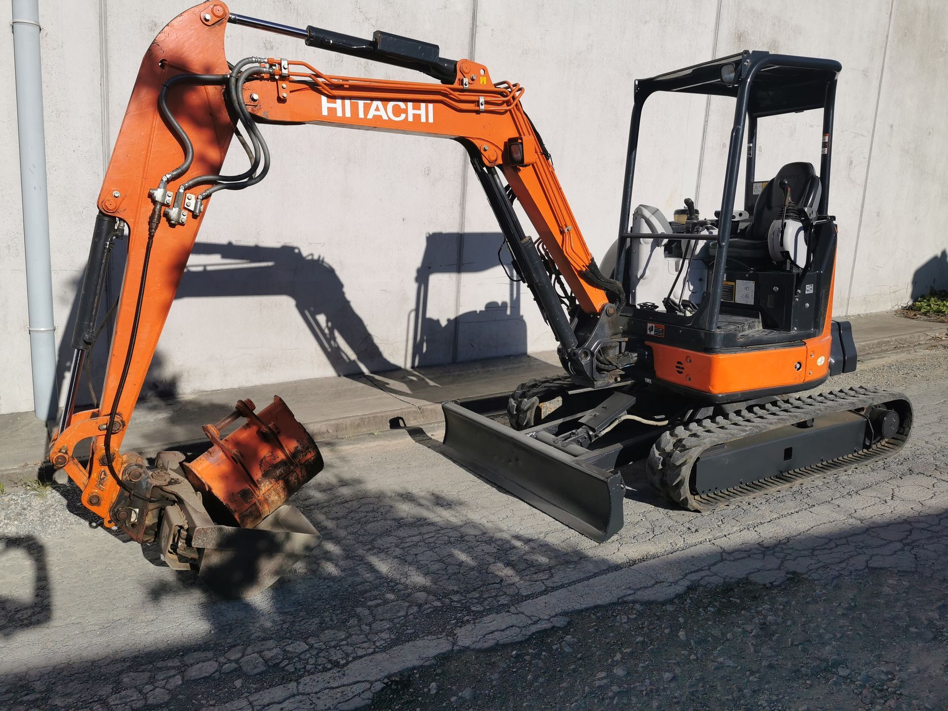 A hitachi excavator is parked on the side of the road