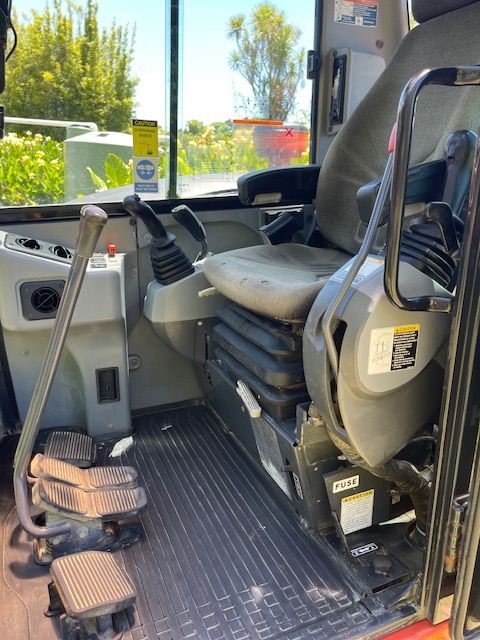 Wheelchair-accessible bus interior with ramp, tie-downs, and driver’s seat near the open door.