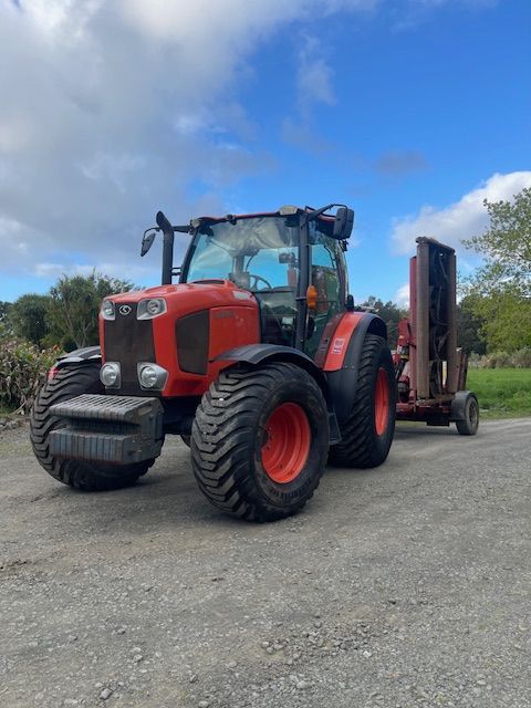 A red and black tractor with a trailer attached to it