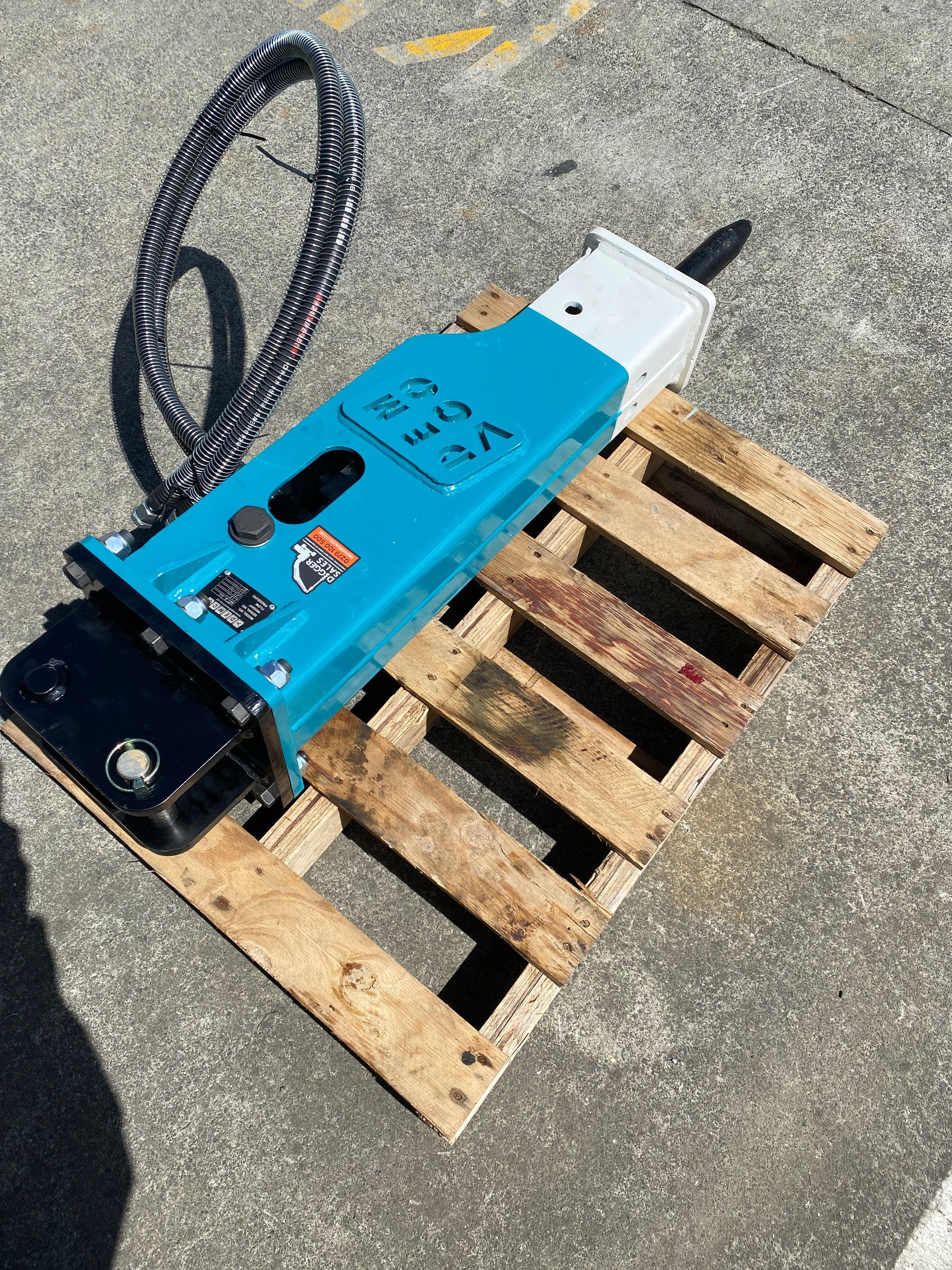 A blue and white machine is sitting on a wooden pallet.