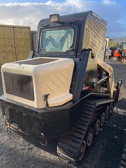 A black and white tractor is parked in a parking lot.
