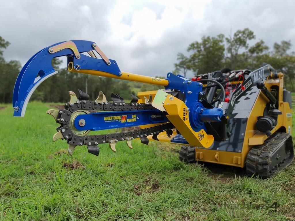 A yellow and blue machine is sitting in a grassy field.