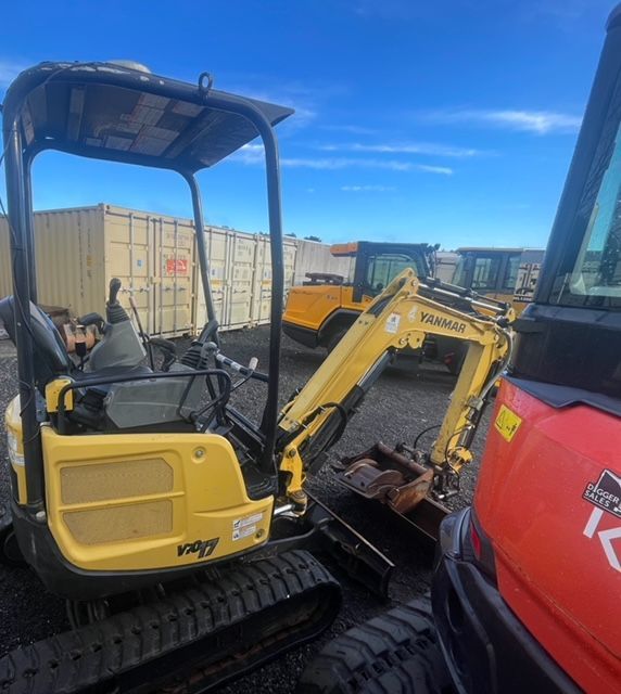 A yellow komatsu excavator is parked next to a red kubota excavator