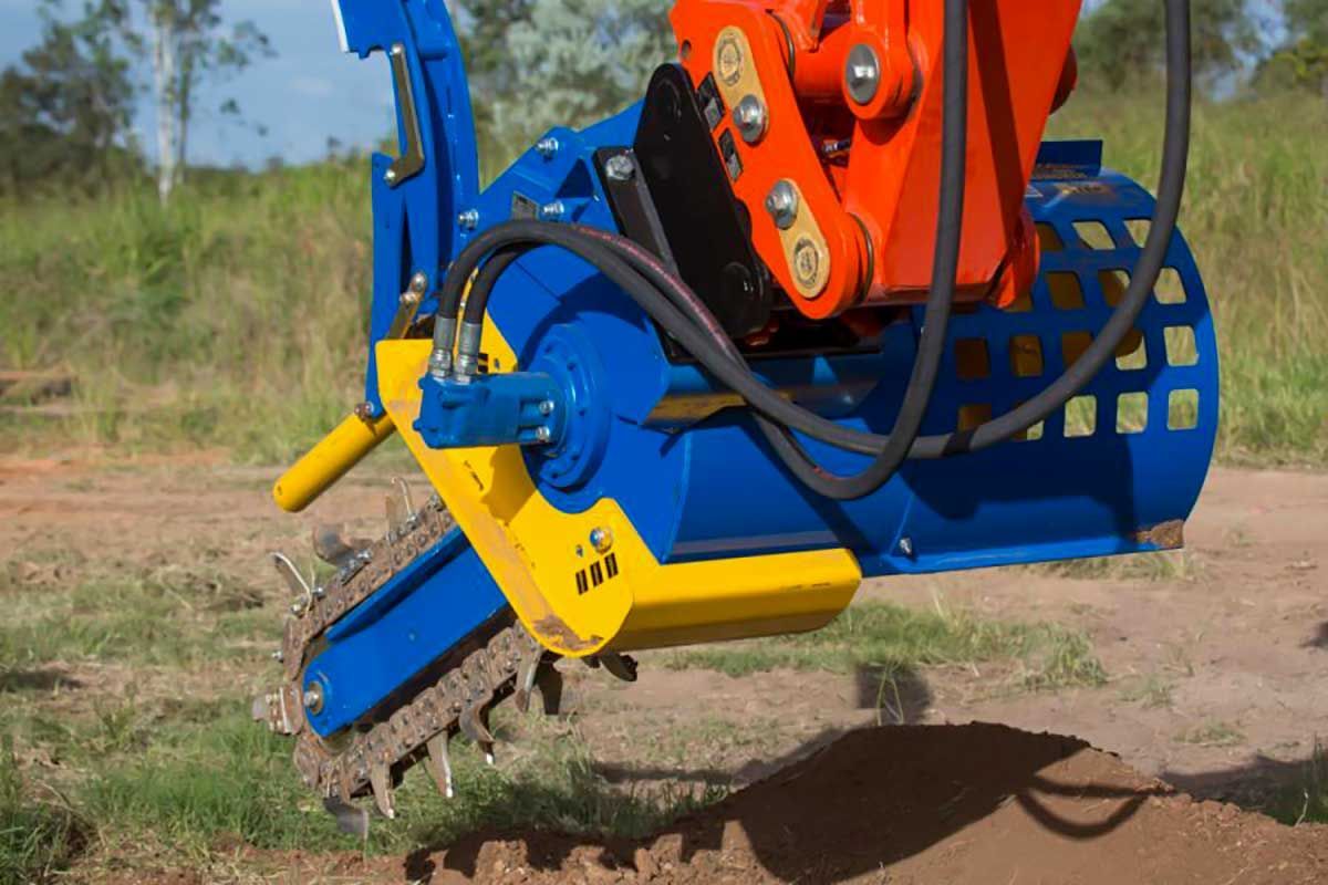 A blue and yellow machine is digging a hole in the ground.