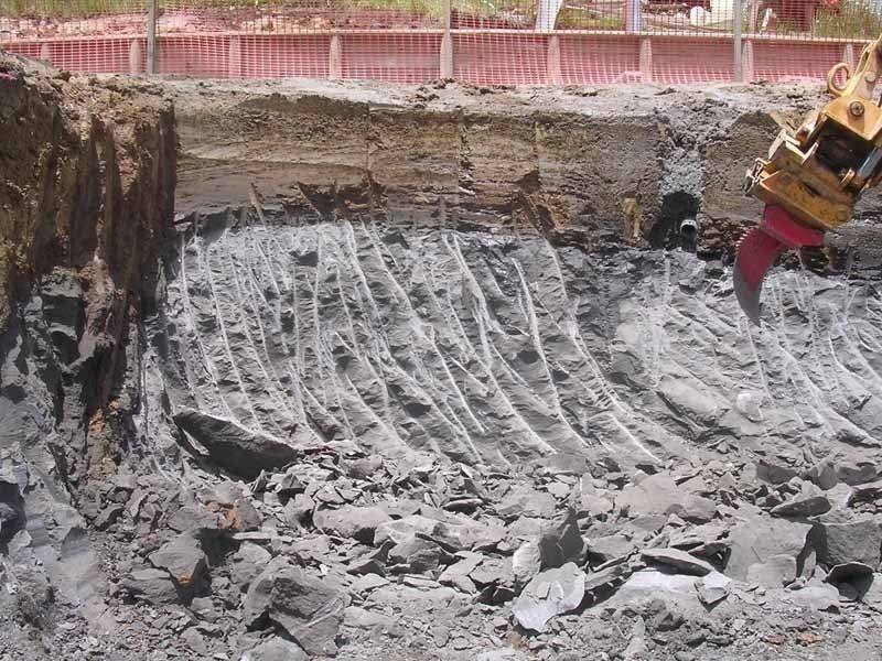 A large pile of rocks is being moved by a machine.