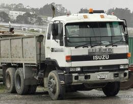 A white dump truck is parked in a parking lot.