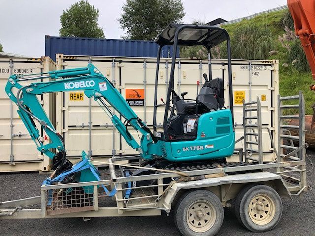 A kobelco mini excavator is on a trailer