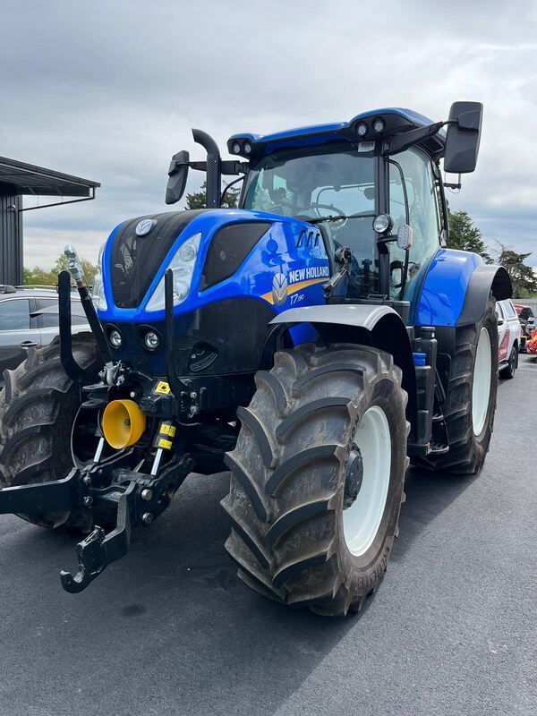 A blue tractor is parked on the side of the road.