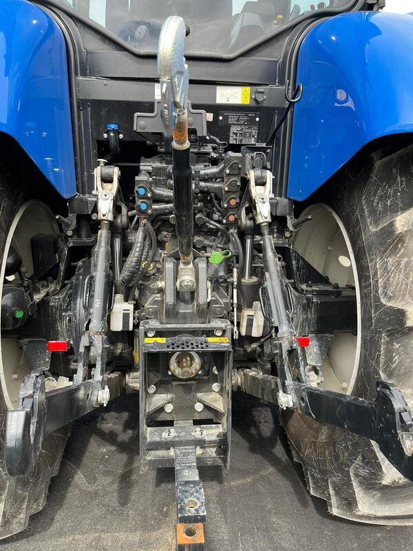 A blue tractor is parked on the side of the road