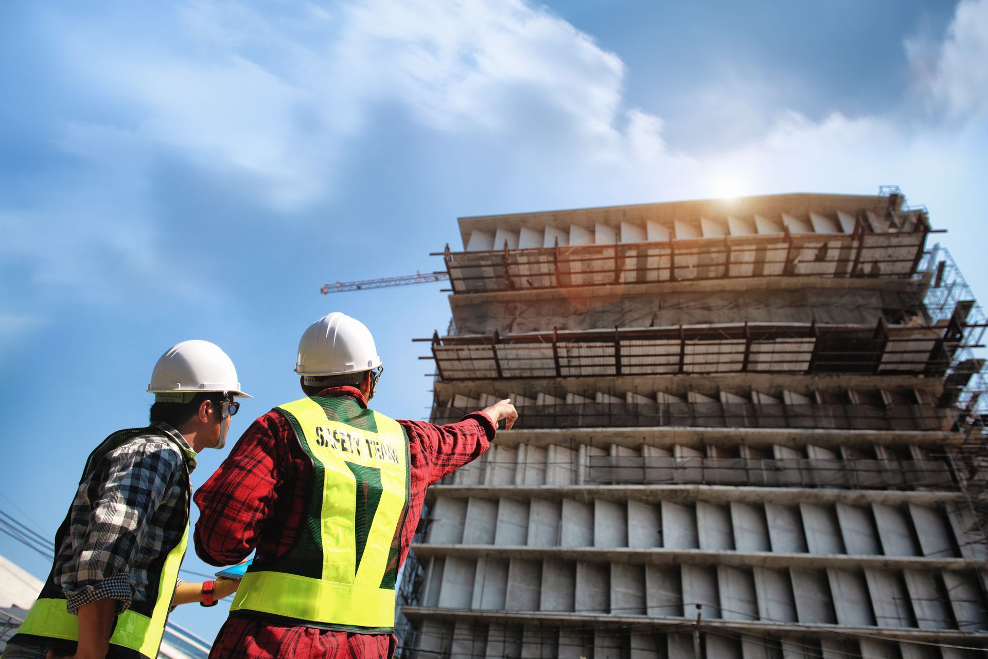 Two civil contractors are overseeing a construction.