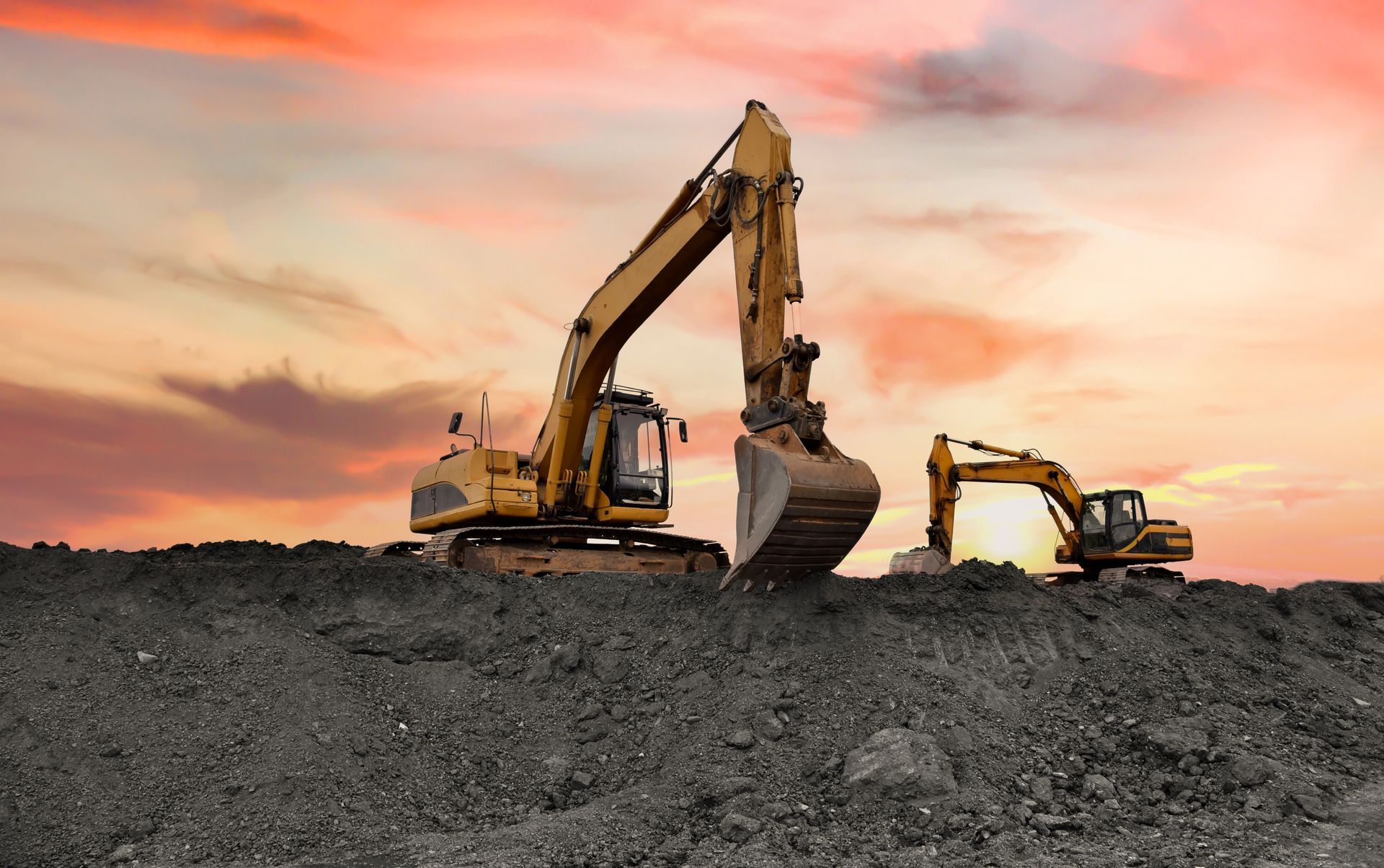 Excavator on earthmoving at open pit mining. Backhoe dig ore in quarry on sunset. Heavy construction equipment and Heavy Machinery during excavation on Mine Site. Mining